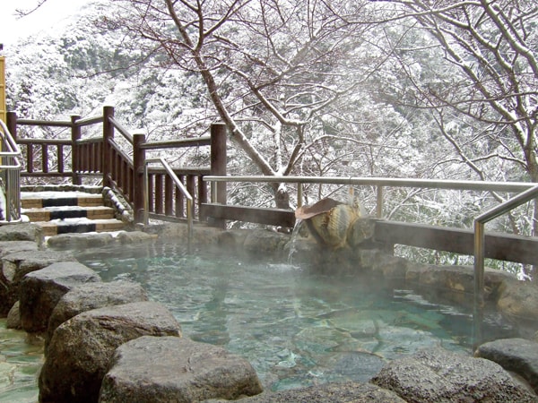 【露天風呂（冬）】信貴山の大自然を望む露天風呂。四季折々の景色を眺めながら湯浴みを愉しむ