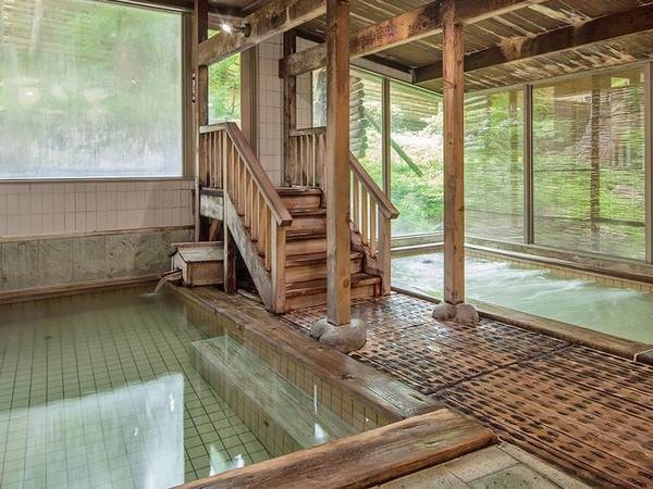 【あじゃらの湯】ほのかに木の香り漂う、広くゆったりした開放的な大浴場です。周辺を緑で囲まれた開放感とともに温かなお湯でのんびりとお寛ぎください。