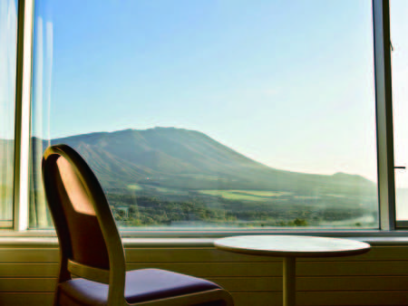 【岩手山側客室・眺望/例】窓から雄大な景色を一望する