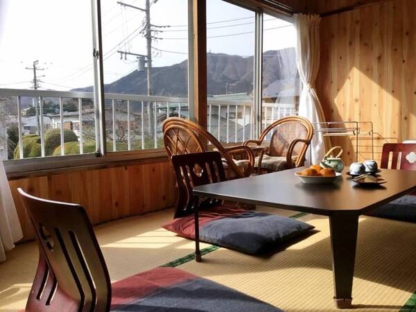 *【和室12畳】景色を見渡せる大きな窓の傍には、ゆったりお寛ぎいただける籐の椅子をご用意。