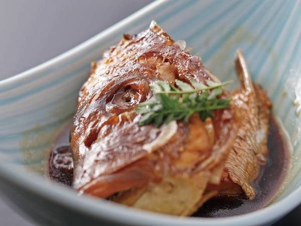 【夕食料理一例】「鯛のあら焚き」鯛の頬肉は井よりも脂が多いため特に味わい深く、コラーゲンも豊富。地元の加賀しょうゆで魚の旨味を引き出し、濃いめのこっくりした味わいがお酒にもご飯にもよく合う
