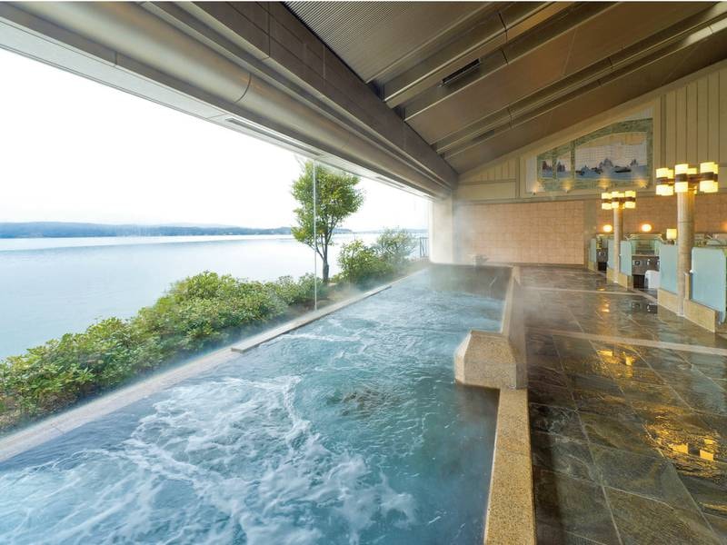 【大浴場/夕なぎの湯】七尾湾に面した浴槽は全面ガラス張り！能登島の姿もくっきりと見える