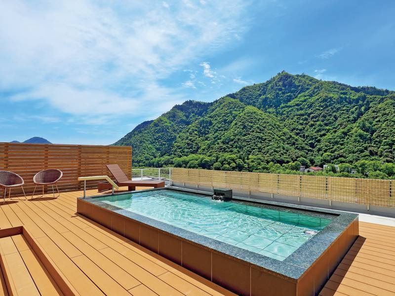 【屋上露天風呂（日中）】清流長良川の穏やかな流れと、金華山の山頂に佇む岐阜城を望む。