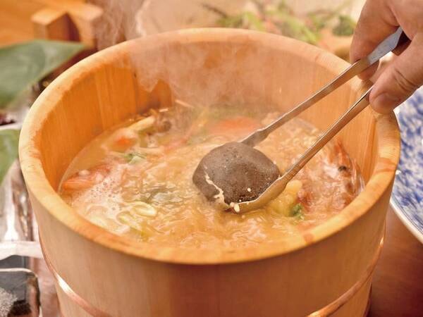 【石焼き桶鍋/例】アツアツの焼き石を投入して沸騰させる宿の名物料理