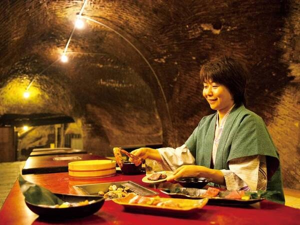 【食事会場】洞窟の中に設えたお座敷で、上質なお肉や新鮮な魚介を網で焼いていただくスタイルが人気！