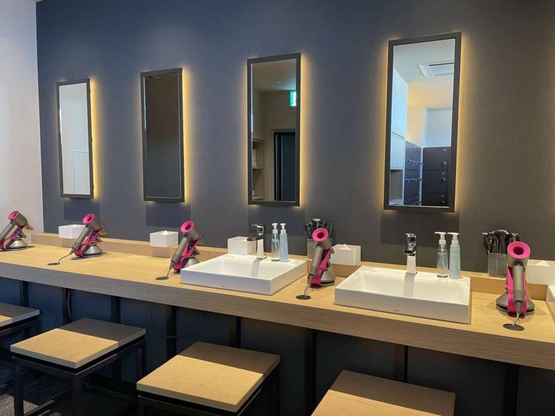 【14階大浴場・露天風呂/脱衣スペース】席ごとの鏡と高性能でスタイリッシュなドライヤーを設置