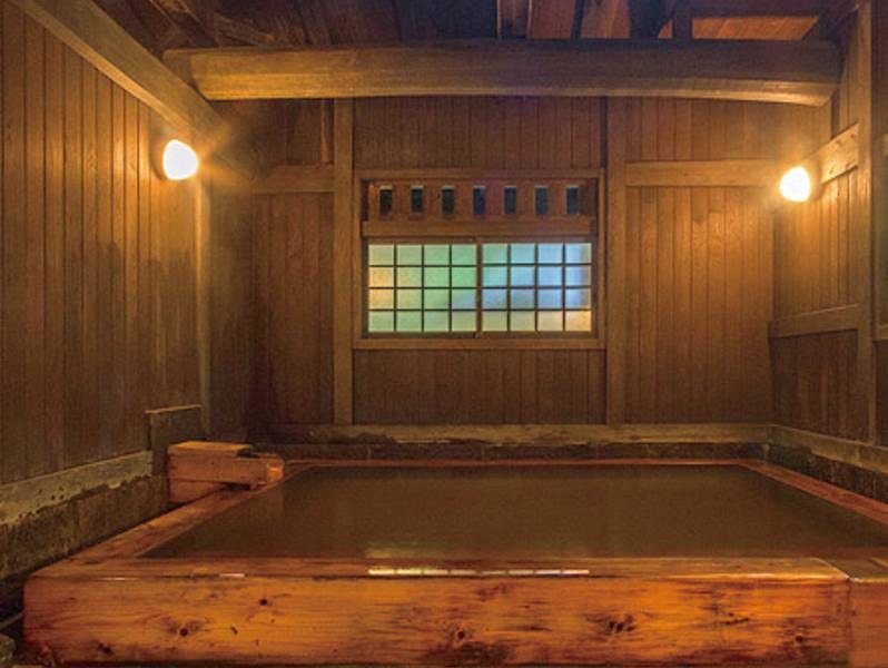 【大浴場/薬師の湯】露天風呂とは異なる泉質で、かすかな硫黄の香りと茶褐色の湯の花が舞うお湯