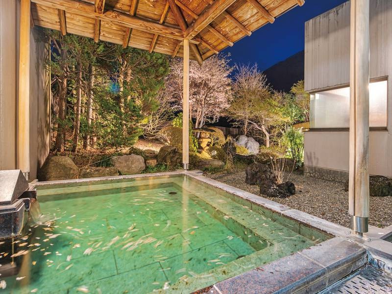 【男性大浴場：露天風呂】四季によって風景の変わる庭園を望みながら湯船に浸かれる
