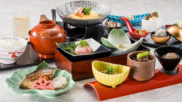 ご朝食：写真一例／季節の和食膳をご用意。健康長寿のまち・京丹後ならではのバランス良く体にやさしい食材を中心に、からだにやさしい品々を少しずつ取りそろえた、料理長こだわりの和朝食膳