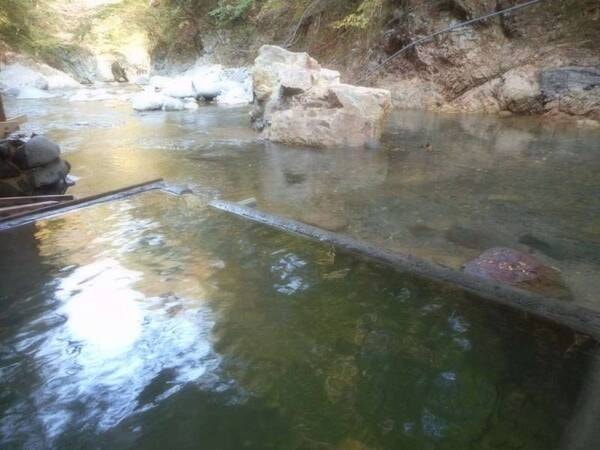 【川岸露天風呂】15年9月の水害後に復旧した浴槽。川面に手が届きそうな近さです。自然との一体感をお愉しみください。