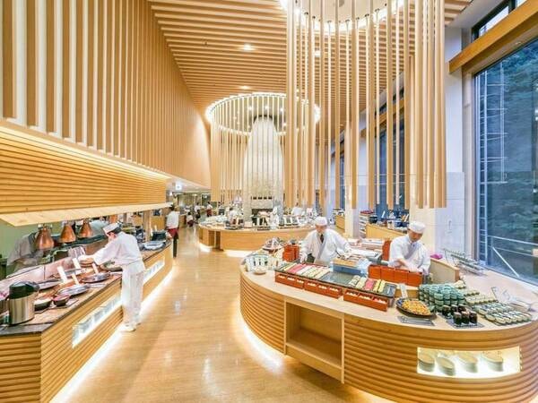 【食事会場「エルバージュ」】全長約15mのライブキッチンカウンターとレストランのシンボル石窯には料理人が並び、出来立て料理をご提供