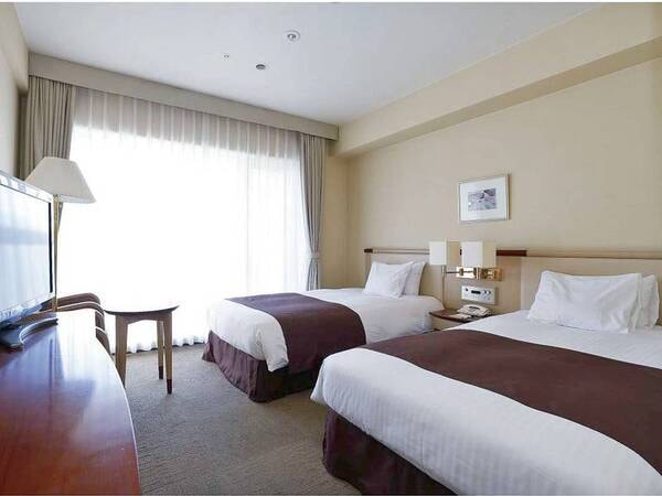 【ツインルーム/例】シモンズ社製ベッドを完備。窓から駅前広場を眺められる