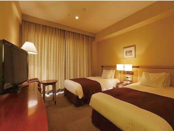 【ツインルーム/例】シモンズ社製ベッドを完備。窓から駅前広場を眺められる