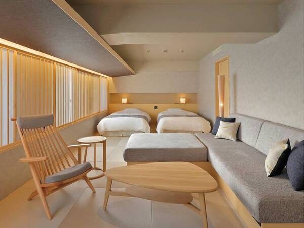 【西館客室ひだまり】ツインベットを設え、お部屋のセンターにはゆったりしたソファを設置/例