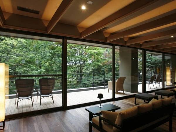 【談話室】天井まで開放された大きな窓に時のうつろいを映す日本庭園の眺め