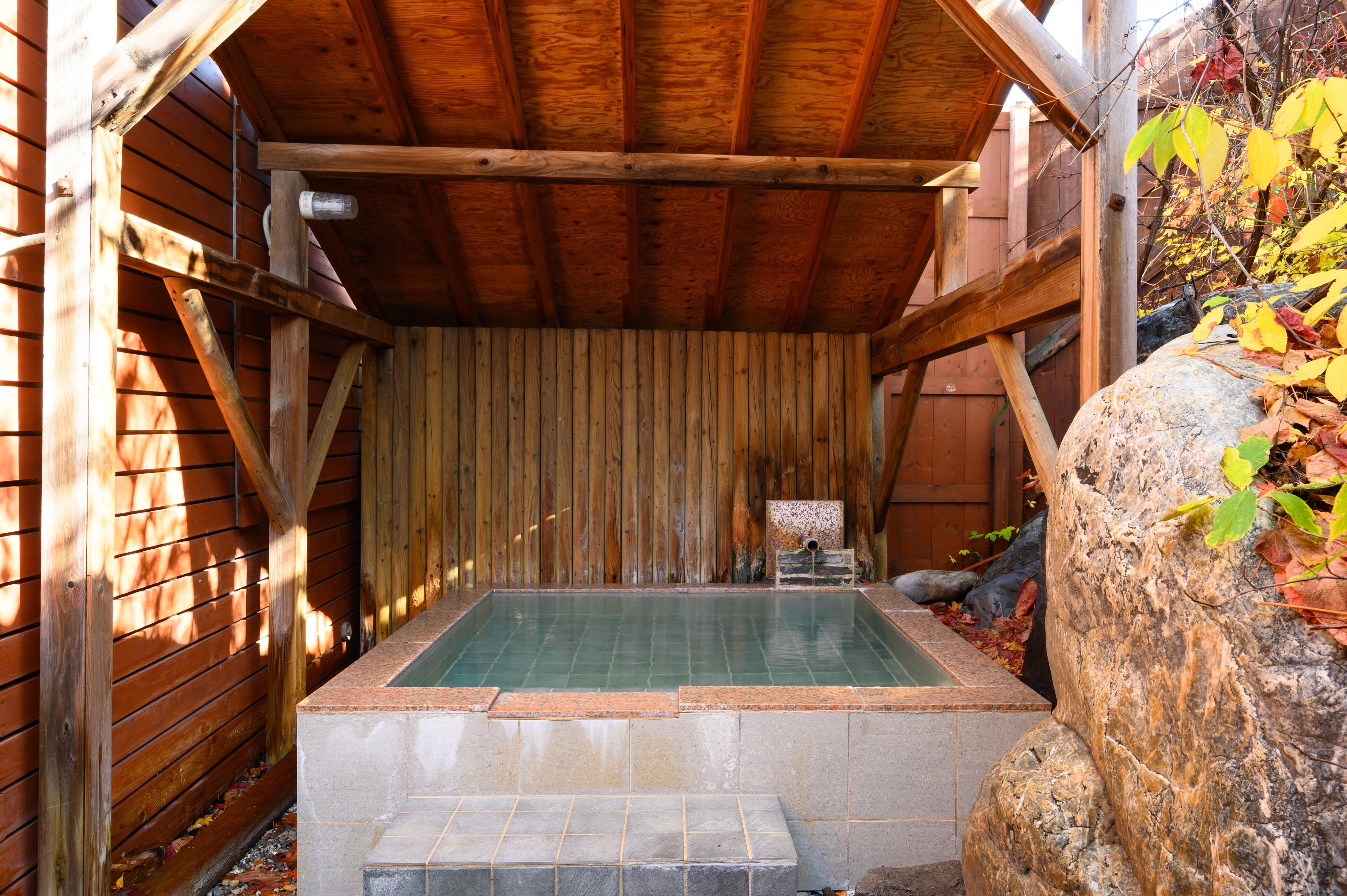 木の露天風呂は男性、岩肌の露天風呂は女性のお客様にご利用いただいております