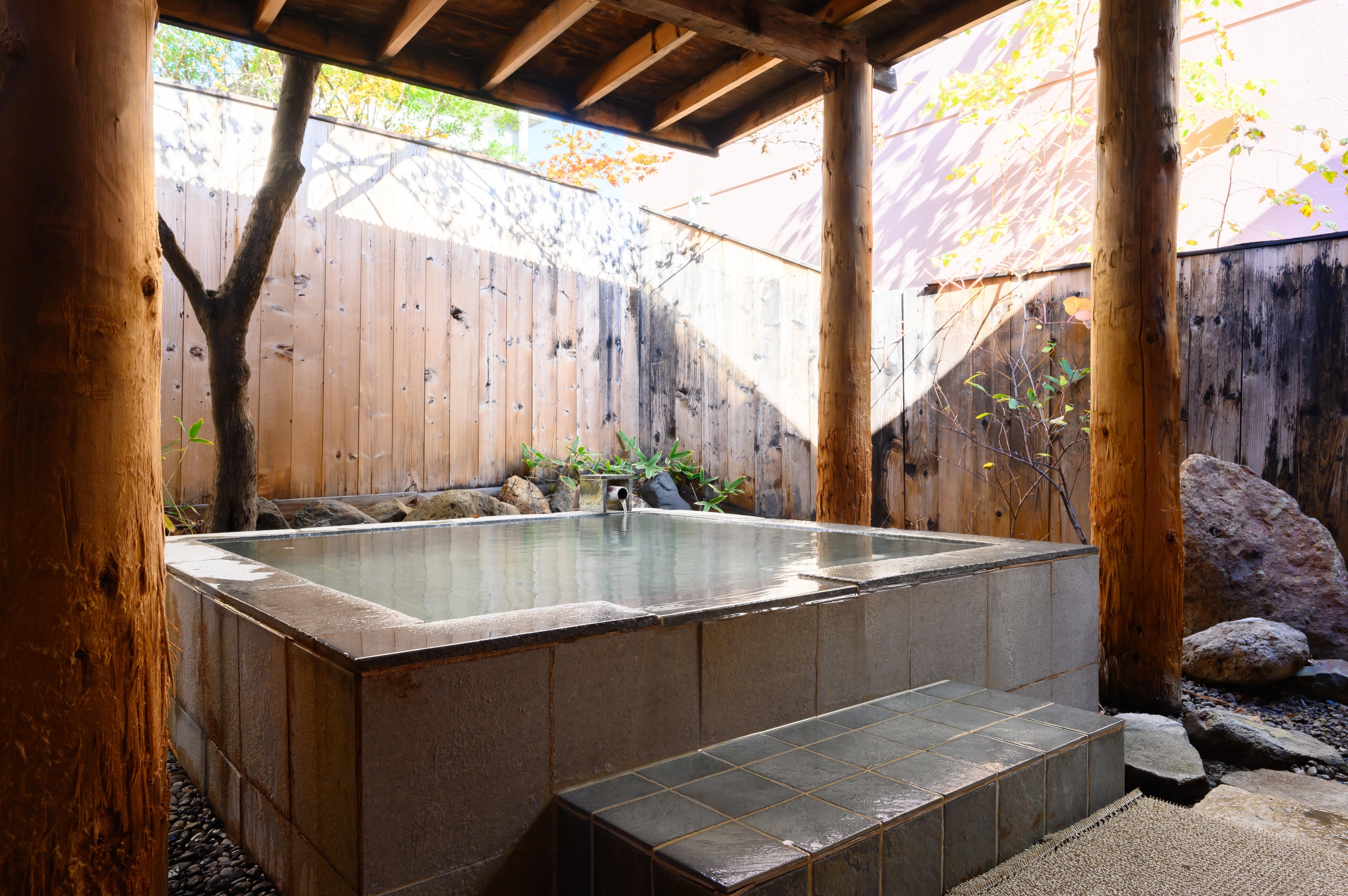 木の露天風呂は男性、岩肌の露天風呂は女性のお客様にご利用いただいております