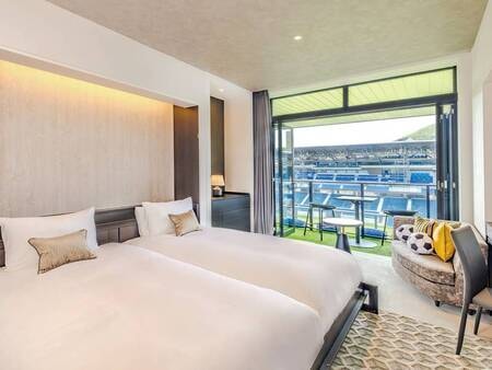 【スタンダードスタジアムビューEXCツイン/例】長崎スタジアムシティのスタジアムをコンセプトにした客室は、サッカーをテーマにしたアートやデザインが随所に施されています。