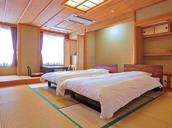 【西館(新館)和風ツイン掘り炬燵和室10畳/例】ツインベッドと掘り炬燵のテーブルがございます。